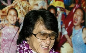 Hong Kong actor and director Jackie Chan smiles past a crowd of cheering fans.