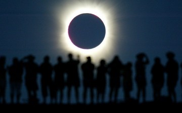 Tourists watch the sun being blocked by the moon during a solar eclipse in the Australian outback town of Lyndhurst, located around 700 kilometres (437 miles) north of Adelaide December 4, 2002. The town is one of only four in Australia where the 26 secon