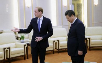 Britain's Prince William (L) gestures next to Chinese President Xi Jinping.