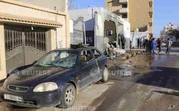 Civilians and security personnel stand at the scene of an explosion at a police station in the Libyan capital Tripoli March 12, 2015. 
