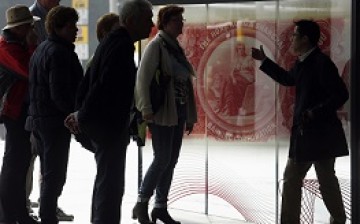 A group of visitors listens to a guide discussing about a display at Hong Kong and Shanghai Banking Corporation headquarters in Hong Kong.