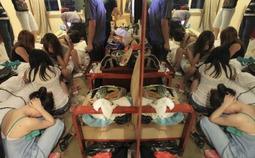 Women are seated during a police crackdown on prostitution in Wenzhou, Zhejiang Province, Sept. 12, 2012.