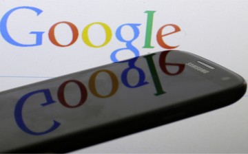 A Google logo is reflected on the screen of a Samsung Galaxy S4 smartphone in this photo illustration taken in Prague January 31, 2014. Google Inc and Samsung Electronics Co Ltd, which are frequently involved in patent infringement lawsuits but not agains
