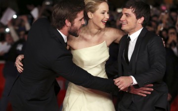 Cast members Jennifer Lawrence (C), Liam Hemsworth (L) and Josh Hutcherson (R) arrive for the screening of the movie 