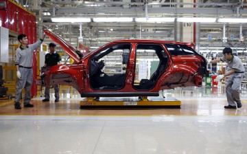 Employees work at the production line inside the Chery Jaguar Land Rover plant before the plant's opening ceremony in Changshu, Jiangsu Province.