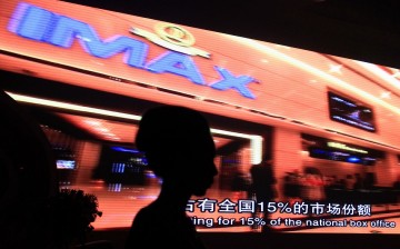 A model stands in front of a video presentation before the start of an official signing ceremony between Wanda Group and AMC Entertainment in Beijing.
