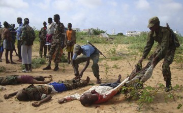 A Somali government soldier drags the dead body of an Islamic al-Shabab fighter killed during fighting