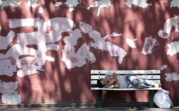 A man sleeps in a bench along Changan Avenue in Beijing.
