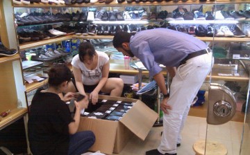 A customer looks at fake foreign brand shoes inside a store at Baiyun World Leather Market in the southern Chinese city of Guangzhou.