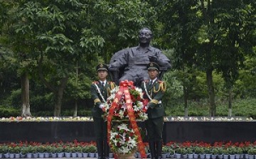 Paramilitary policemen place a flower basket at the statue of late Chinese leader Deng Xiaoping on the 110th anniversary of his birth in Guang'an, Sichuan Province.