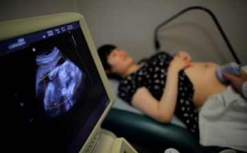 A woman who is five months pregnant with her second child takes a sonogram at a local hospital in Shanghai.