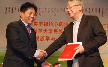 Inner Mongolia Normal University President Yun Guohong and Assistant to the President of the Chinese Academy of Social Sciences Hao Shiyuan shake hands during the unveiling ceremony for the school.