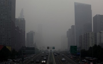 A view of Jianguo Road on a hazy day in Beijing's central business district .