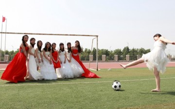 College graduates pose for a photograph with a soccer ball and a goal post on a soccer field at Yuncheng University in Yuncheng, Shanxi Province.