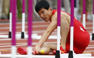 China's Liu Xiang holds his leg after suffering an injury in his men's 110m hurdles round 1 heat at the London 2012 Olympic Games at the Olympic Stadium, Aug. 7, 2012. 