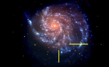 That same galaxy in a NASA Swift image is shown, with bars indicating the location of supernova SN 2011fe. The Swift image is a false-color image with UV emission blue and optical emission red.