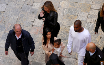 Toddler North West was baptized in Jerusalem on Monday, accompanied by mom Kim Kardashian (center) and father Kanye West (second from right).