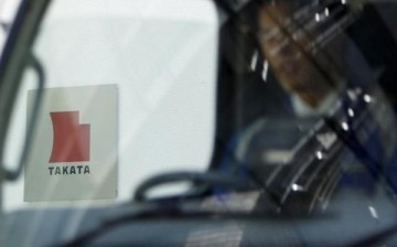 A logo of Takata Corp is seen through a car window outside the company's headquarter building in Tokyo.