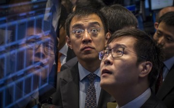 58.com CEO Jinbo Yao (R), watches as his company is priced during its IPO at the New York Stock Exchange. 
