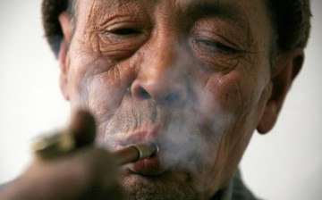 A farmer smokes a pipe after collecting firewood in his fields located near the village of Da Shi Men, around 80 kilometers (50 miles) northeast of Beijing.