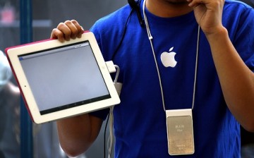 An Apple store employee shows how to use the new iPad 2 during the China launch at an Apple Store in central Beijing.