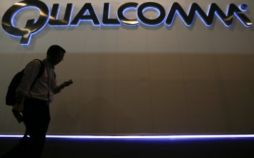 Man walks past Qualcomm stand while attending the Mobile World Congress in Barcelona March 3, 2015. Ninety thousand executives, marketers and reporters gather in Barcelona this week for the telecom op
