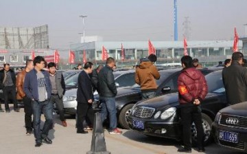 Visitors look at the second batch of to-be-auctioned government vehicles at a preview exhibition in Beijing, March 15, 2015.