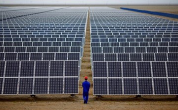 A worker inspects solar panels at a solar farm in Dunhuang, 950 kilometers (590 miles) northwest of Lanzhou, Gansu Province.