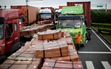 Trucks carrying copper and other goods are seen waiting to enter an area of the Shanghai Free Trade Zone.