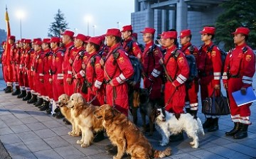 Members of Chinese International Search and Rescue Team and their rescue dogs line up before boarding a charted plane to Kathmandu.