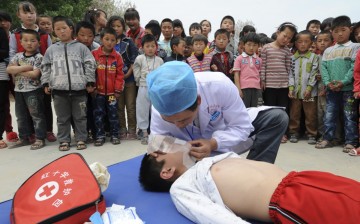 A volunteer from Red Cross Society of China demonstrates CPR to students at a primary school in Shandong Province. 