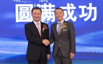 Wang Jianlin, chairman of Dalian Wanda Group Co., and Yu Liang, CEO of China Vanke Co. Ltd., shake hands after the signing of a strategic cooperation agreement on May 14, Thursday, in Beijing.
