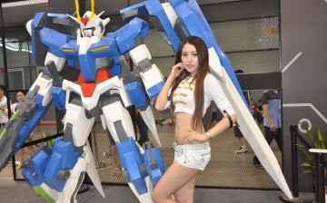 A model showing off her skin beside a robot replica at the 2014 China Digital Entertainment Expo & Conference, also known as ChinaJoy.