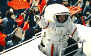 Chinese taikonaut Zhai Zhigang emerges from a simulated Shenzhou-7 capsule and waves a national flag during the celebrations for the 60th anniversary of the founding of the People's Republic of China.