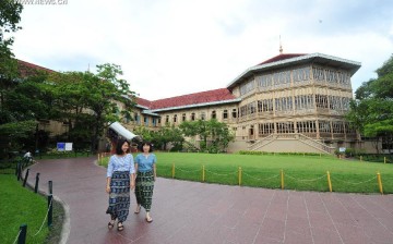 Chinese visitors strolling in front of Vimanmek Mansion, a former royal palace in Bangkok, Thailand.