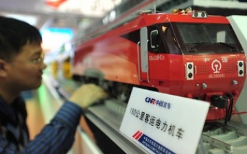 A visitor takes a look at a model locomotive train made by China CNF at an exhibition in Beijing. 