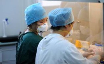 Two experts from the Chinese Center for Disease Control and Prevention do experiments at the virus lab of the Fuyang Disease Control Center in Fuyang, Anhui Province.