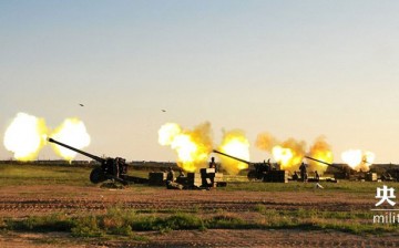 Photo shows shells bursting out of cannons during a military school graduation drill in a costal military training base alongside the Bohai Sea. 