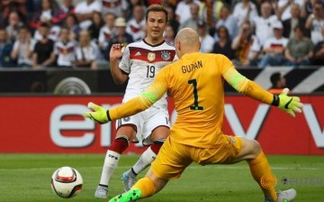 Mario Goetze (L) of Germany attacks Brad Guzan of the U.S.