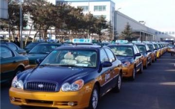 Who's going to drive? A fleet of brand-new taxi cabs with seats still covered in plastic.