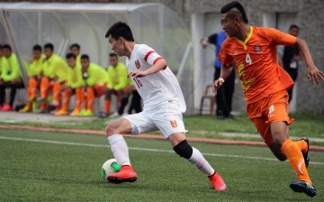 Bhutan's Jigme Tshering Dorji tries to defend against China's Sun Ke (L) during the FIFA World Cup 2018 qualifying match at the Changlimithang Stadium in Thimphu on June 16, 2015. 