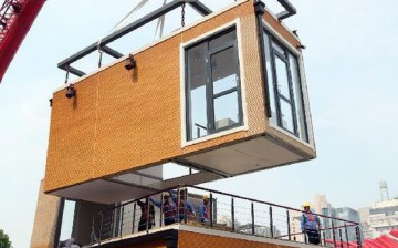 Construction workers erect an eco-friendly modular building at Shijiazhuang Liberation Square in Shijianzhuang, north China's Hebei Province on June 20, 2015.