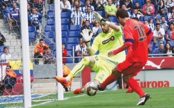 Kiko Casilla attempts to block a shot by Lionel Messi.