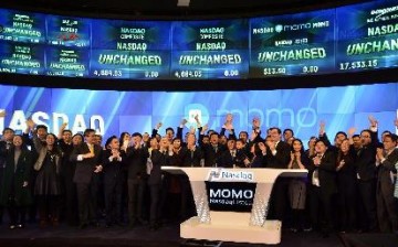 Yan Tang, founder and CEO of social networking platform Momo Inc., and employees attend the ceremony of ringing the opening bell at the NASDAQ in New York, on Dec. 11, 2014.