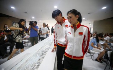 Chinese athletes pore over “Jingji Winter Joy,” a scroll painting celebrating Beijing’s bid for the 2022 Winter Olympic Games.