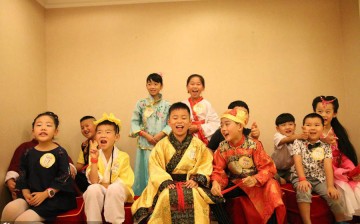 A group photo of children in traditional Chinese garment during a children's traditional cultural fashion show in Wuhan, the capital city of central China's Hubei Province, on July 17, 2015. 