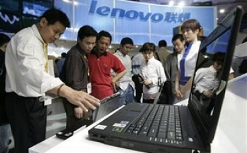 Visitors check a Lenovo computer at the 9th China Beijing International High-Tech Expo held in Beijing in May 2006.