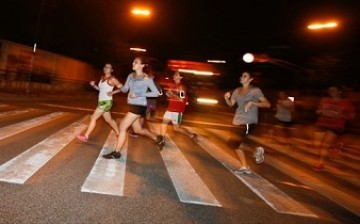 Runners take the path along the riverbank in Xuhui District in a weekly night event.