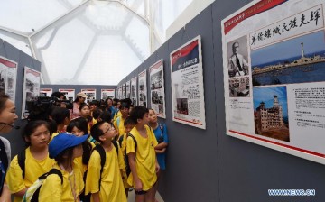 Youth visit a photo exhibition on World War II at National Aquatics Center in Beijing, Aug. 4, 2015.