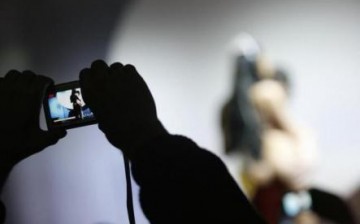 A visitor takes pictures of an adult film actress while she performs during the Eros Show in the Bulgarian capital Sofia March 25, 2009.